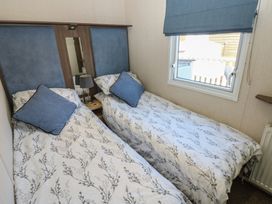 A bedroom with two single beds and a window at Plot 42 in Armathwaite