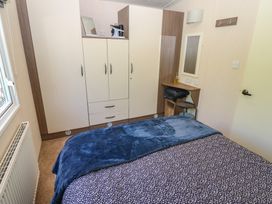 A bedroom with a bed and wardrobe at Plot 42 in Armathwaite