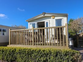 A cabin with a deck and seating area at Plot 42 Armathwaite