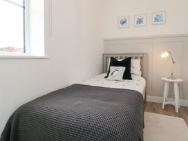 A bedroom with a bed and bedside table at The Nest