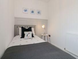 A bedroom with a single bed and a table lamp at The Nest 