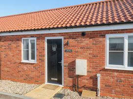 An exterior view of a brick building with a door and windows at The Nest in Buckton near Bridlington