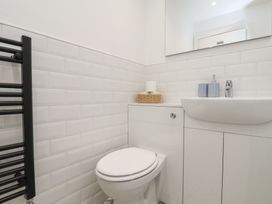 A bathroom with a toilet and sink with storage at The Nest in Buckton near Bridlington