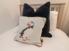 A bed with decorative pillows at The Nest in Buckton near Bridlington