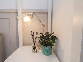 A table with a lamp, reed diffuser, and a potted plant at The Nest in Buckton near Bridlington