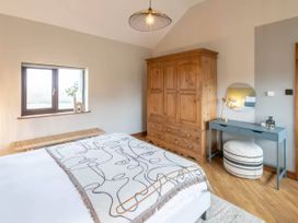 A bedroom with a bed and wardrobe at Black Bird Cottage Llangaffo