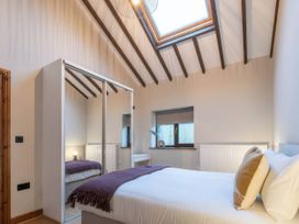 A bedroom with a bed and wardrobe at Black Bird Cottage in Llangaffo
