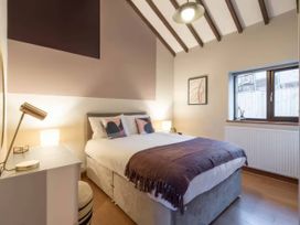 A bedroom with a bed and lamp at Black Bird Cottage in Llangaffo