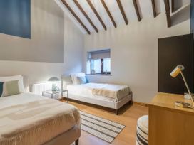 A bedroom with two beds and a window at Black Bird Cottage in Llangaffo