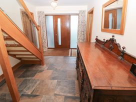 An entrance hall with a console table and staircase at Ty-Gan Dderwen in Llanelli