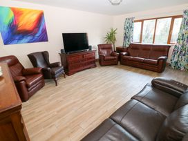 A living room with leather sofas and a television at Ty-Gan Dderwen in Llanelli