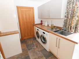 A laundry room with a washer and dryer at Ty-Gan Dderwen in Llanelli