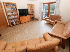 A living room with a television and sofa at Ty-Gan Dderwen in Llanelli