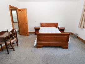 A bedroom with a bed and desk at Ty-Gan Dderwen in Llanelli