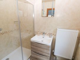 A bathroom with a shower, sink, and radiator at Ty-Gan Dderwen in Llanelli