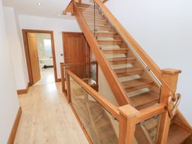 A staircase with wooden handrail and door leading to a bathroom at Ty-Gan Dderwen in Llanelli