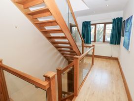 A hallway with a staircase and windows at Ty-Gan Dderwen in Llanelli