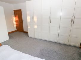 A bedroom with a wardrobe and a door at Ty-Gan Dderwen in Llanelli