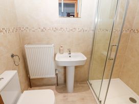 A bathroom with a shower, sink, and toilet at Ty-Gan Dderwen, Llanelli