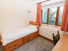 A bedroom with a bed and a desk at Ty-Gan Dderwen in Llanelli