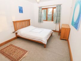 A bedroom with a bed and a window at Ty-Gan Dderwen in Llanelli