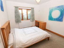 A bedroom with a bed, desk, and chair at Ty-Gan Dderwen in Llanelli