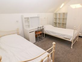 A bedroom with two beds and a desk at Ty-Gan Dderwen in Llanelli