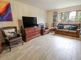 A living room with a sofa and television at Ty-Gan Dderwen in Llangennech