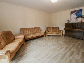 A living room with two sofas and a piano at Ty-Gan Dderwen in Llangennech
