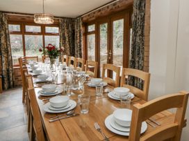 A dining room with a large table set for a meal at Ty-Gan Dderwen in Llangennech