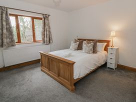 A bedroom with a bed and a window at Ty-Gan Dderwen in Llangennech