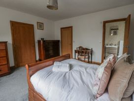 A bedroom with a bed and dresser at Ty-Gan Dderwen in Llangennech