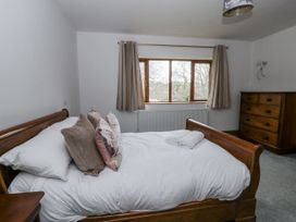 A bedroom with a bed and chest of drawers at Ty-Gan Dderwen in Llangennech
