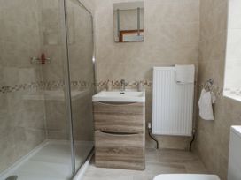 A bathroom with a shower and vanity at Ty-Gan Dderwen in Llangennech