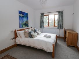 A bedroom with a bed and chest of drawers at Ty-Gan Dderwen in Llangennech