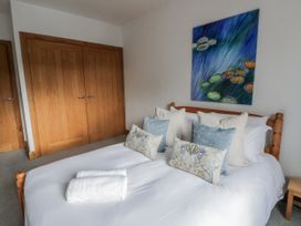 A bedroom with a bed, pillows, and wardrobe at Ty-Gan Dderwen in Llangennech