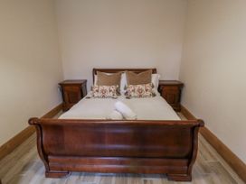 A bedroom with a bed and nightstands at Ty-Gan Dderwen in Llangennech