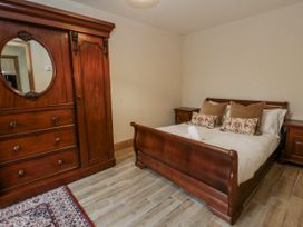 A bedroom with a bed and wardrobe at Ty-Gan Dderwen in Llangennech