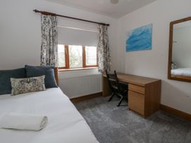 A bedroom with a bed and desk at Ty-Gan Dderwen in Llangennech