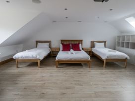 A bedroom with multiple beds and furniture at Ty-Gan Dderwen in Llangennech