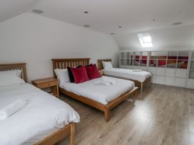 A bedroom with three beds and shelving at Ty-Gan Dderwen in Llangennech
