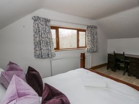 A bedroom with a bed and desk at Ty-Gan Dderwen in Llangennech