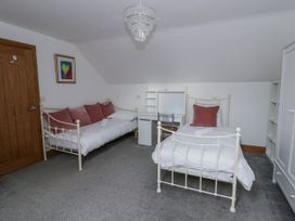 A bedroom with two beds and a desk at Ty-Gan Dderwen in Llangennech