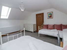 A bedroom with two beds and a chest of drawers at Ty-Gan Dderwen in Llangennech