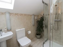 A bathroom with a shower, toilet, and sink at Ty-Gan Dderwen in Llangennech