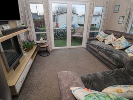 A living room with a sofa and coffee table at Offspray Court 1 Scratby