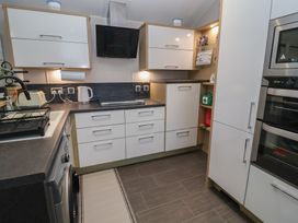 A kitchen with cabinets and appliances at Offspray Court 1 Scratby