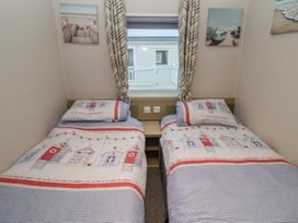 A bedroom with two single beds in Offspray Court 1 Scratby