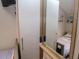 A bedroom with a bed and wardrobe at Offspray Court 1 Scratby