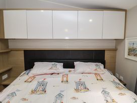 A bedroom with a bed and wardrobe at Offspray Court 1 Scratby